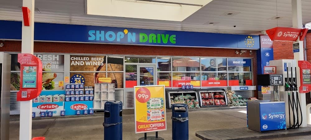 Daytime petrol station forecourt with fuel dispenser and convenience shop entrance